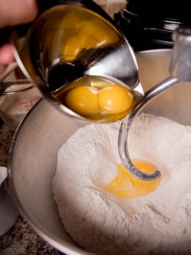 adding eggs to challah dough